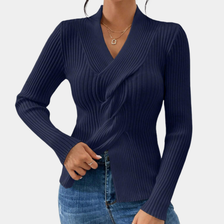 Donkerblauwe geribbelde damestrui met V-hals, lange mouwen en stijlvolle pasvorm, gedragen met een spijkerbroek. Perfect voor casual en chique looks.