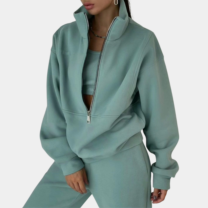 Groen tweedelig joggingpak voor dames, bestaande uit een joggingbroek en een vest met halve rits
