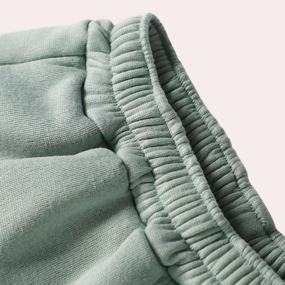 Groen tweedelig joggingpak voor dames, bestaande uit een joggingbroek en een vest met halve rits