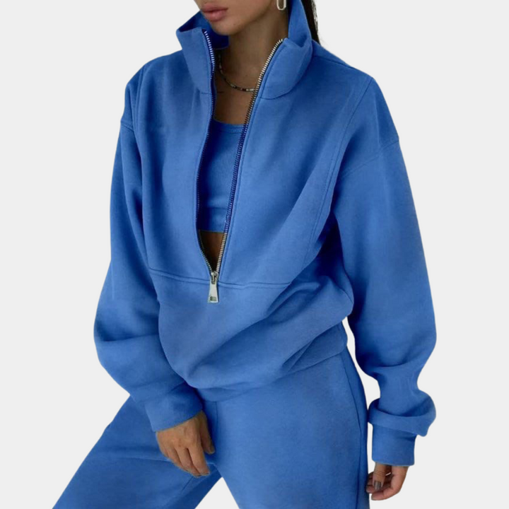 Blauw tweedelig joggingpak voor dames, bestaande uit een joggingbroek en een vest met halve rits
