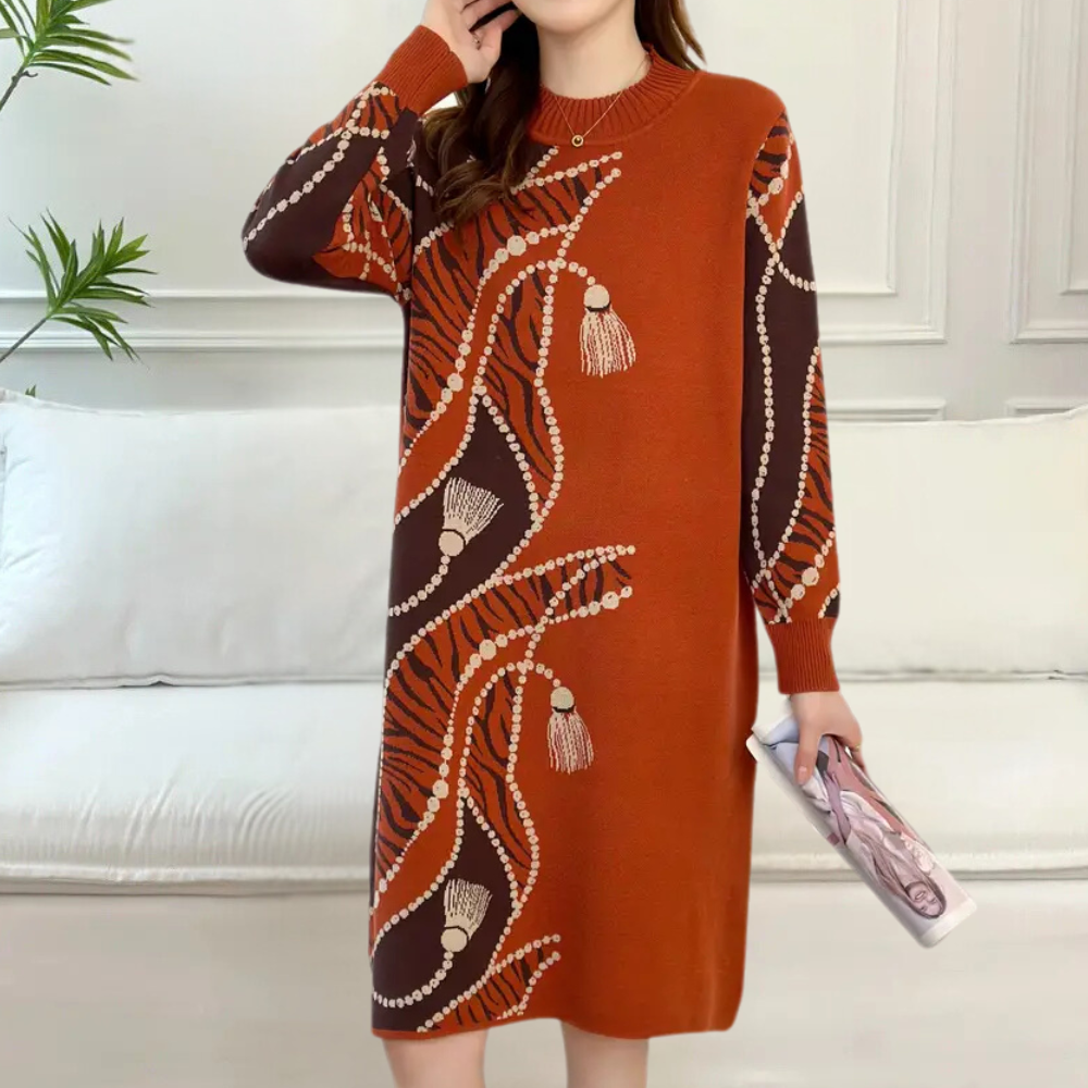 Oranje gebreide jurk met abstract patroon en kwastjes, lange mouwen, comfortabele pasvorm. Perfect voor herfstmode en casual stijl.