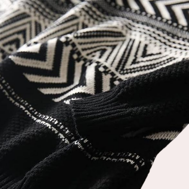 Zwart-witte gebreide trui met geometrisch zigzagpatroon, close-up. Modieuze winterkleding, warme stof, trendy design.