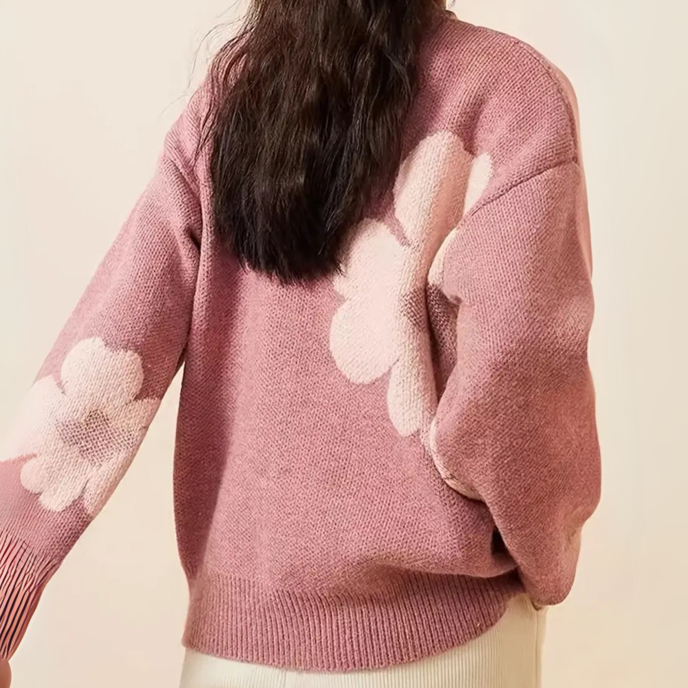 Roze trui met bloemenpatroon, lange mouwen en losse pasvorm. Ideaal voor damesmode, herfst- en winterkleding. Comfortabele en stijlvolle outfit.