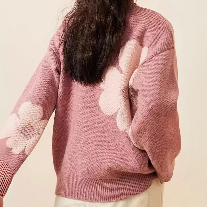 Roze trui met bloemenpatroon, lange mouwen en losse pasvorm. Ideaal voor damesmode, herfst- en winterkleding. Comfortabele en stijlvolle outfit.