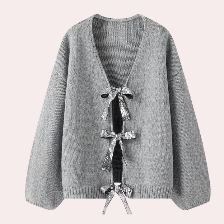 Grijze gebreide damestrui met V-hals en decoratieve striksluitingen, modieuze herfstkleding, comfortabele en stijlvolle damesmode.