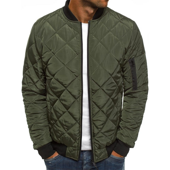 Groene gewatteerde bomberjack voor heren, met zwarte boorden en ritszak op de mouw. Stijlvolle herenjassen, casual mode, winterkleding.