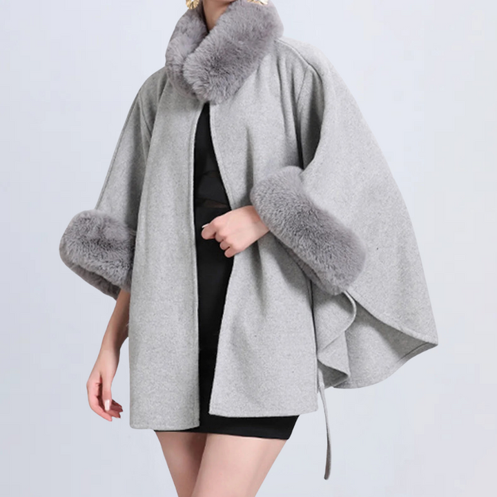 Grijze damescape met bontkraag en manchetten, elegant ontwerp, wintermode, warme wollen stof, stijlvolle kleding voor koude seizoenen.