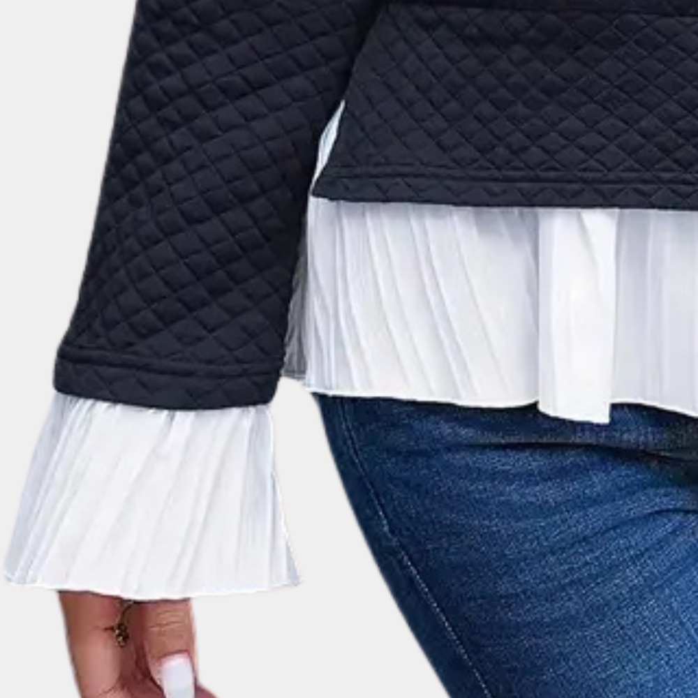 Zwarte gewatteerde jas met witte geplooide blouse en blauwe jeans. Modieuze dameskleding, herfstoutfit, casual stijl.