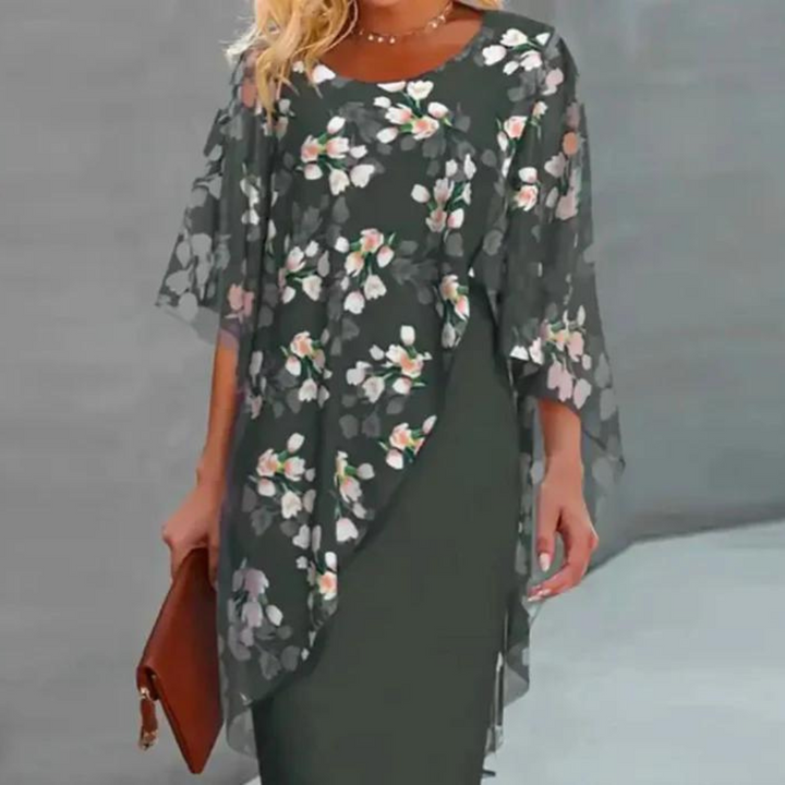 Elegante dames bloemenjurk met transparante bloemenprint, driekwart mouwen en een groene basis. Perfect voor lente- en zomermode.