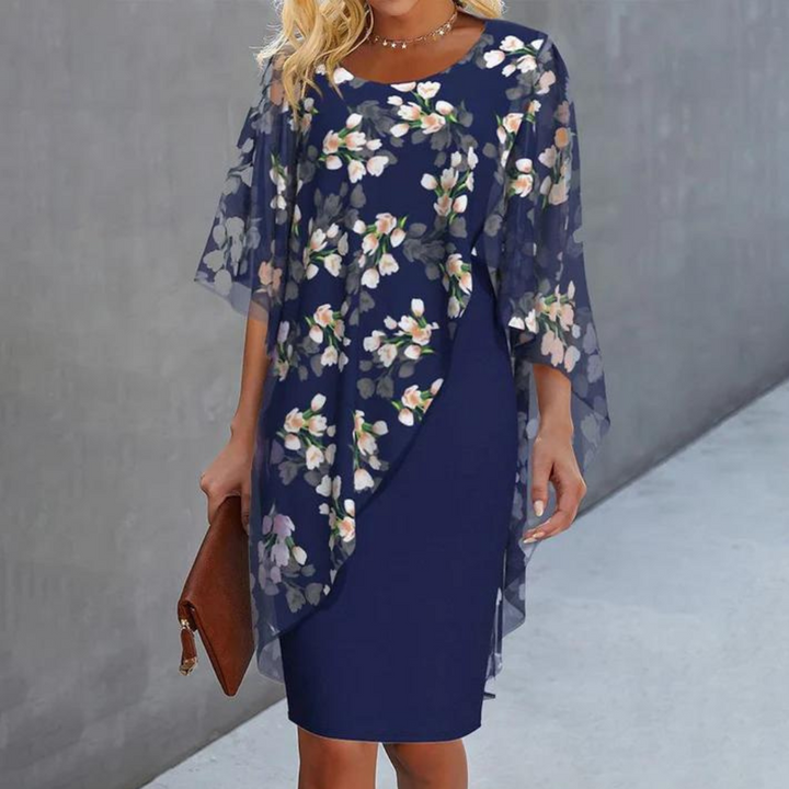 Elegante damesjurk met bloemenprint, donkerblauw, chiffon overlay, geschikt voor lente en zomer. Perfect voor feestelijke gelegenheden.