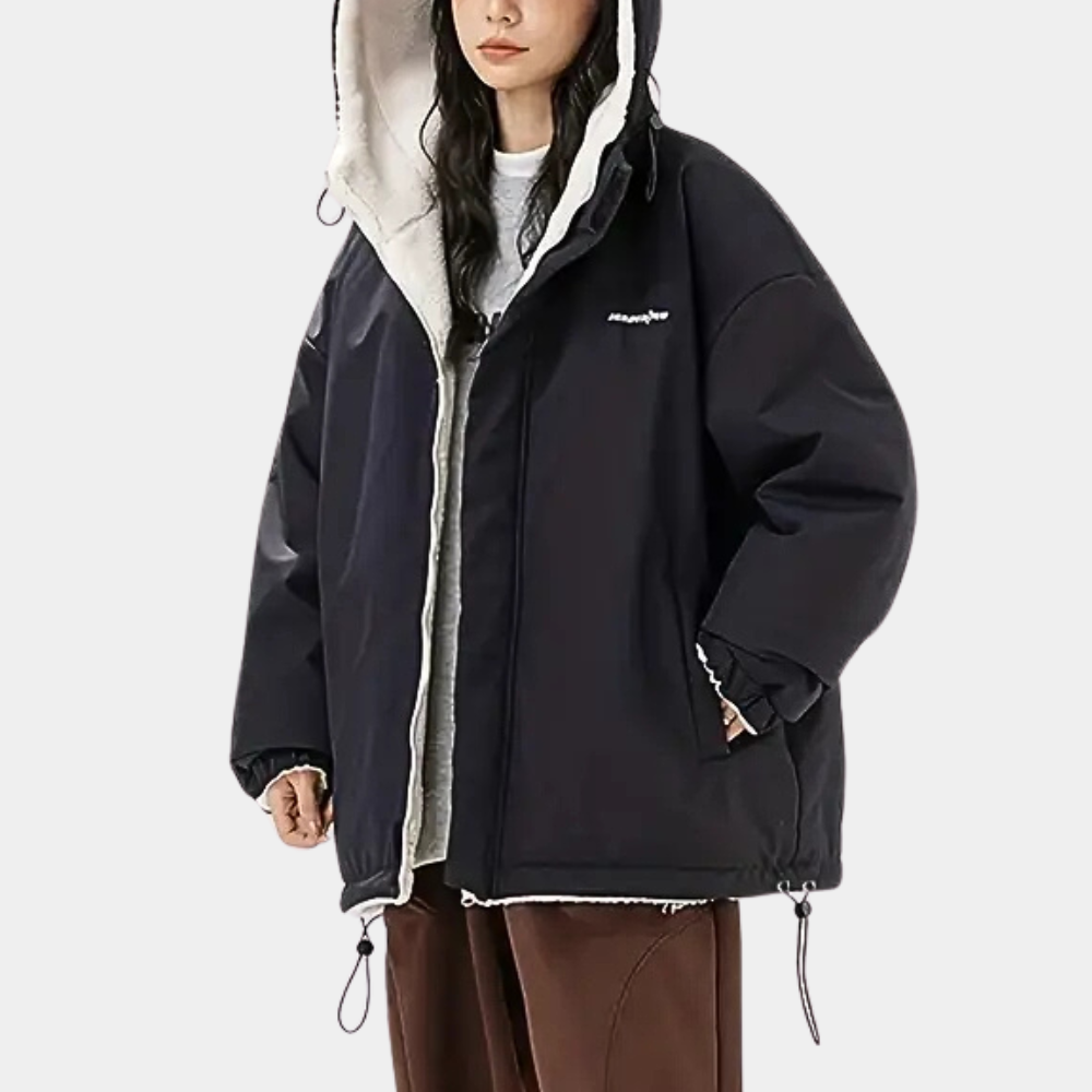 Zwarte oversized winterjas met capuchon, gedragen door model. Warme voering, casual stijl, ideaal voor koude seizoenen. Unisex mode, trendy design.