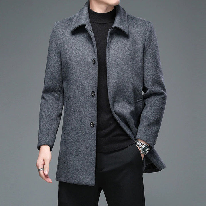 Grijze wollen herenjas, stijlvolle wintermode, gedragen over zwarte trui en broek. Elegante herenkleding, geschikt voor formele gelegenheden.