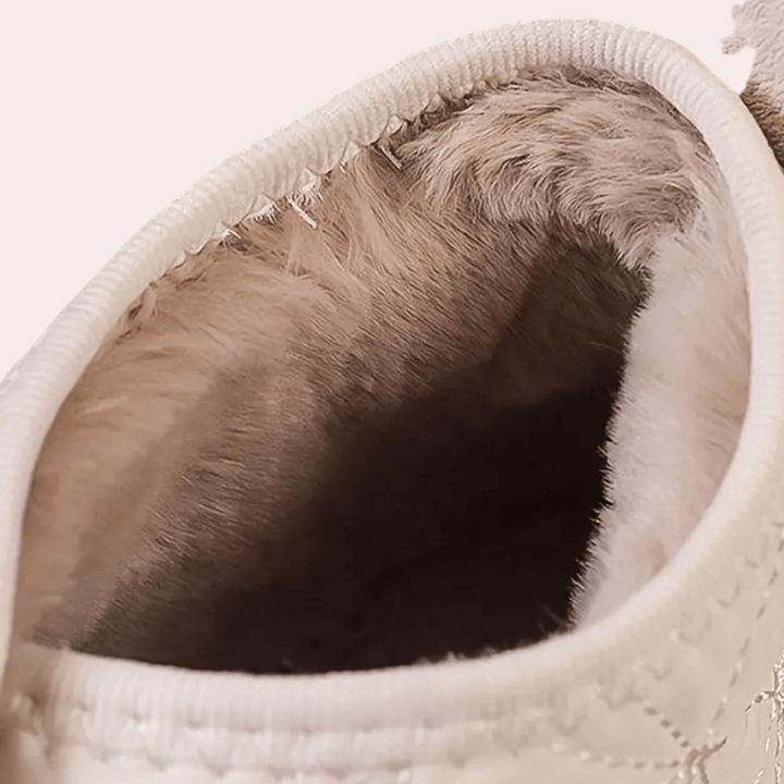 Witte sneaker met zachte, beige voering van imitatiebont, close-up. Comfortabele wintermode, warme schoenen voor dames, trendy en stijlvol ontwerp.