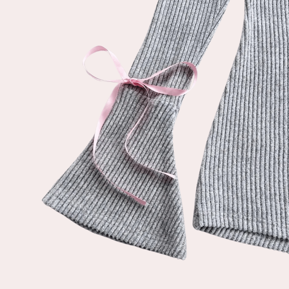 Grijze geribbelde trui met roze strikdetail op de mouw, damesmode, trendy herfstkleding, stijlvolle en comfortabele outfit.