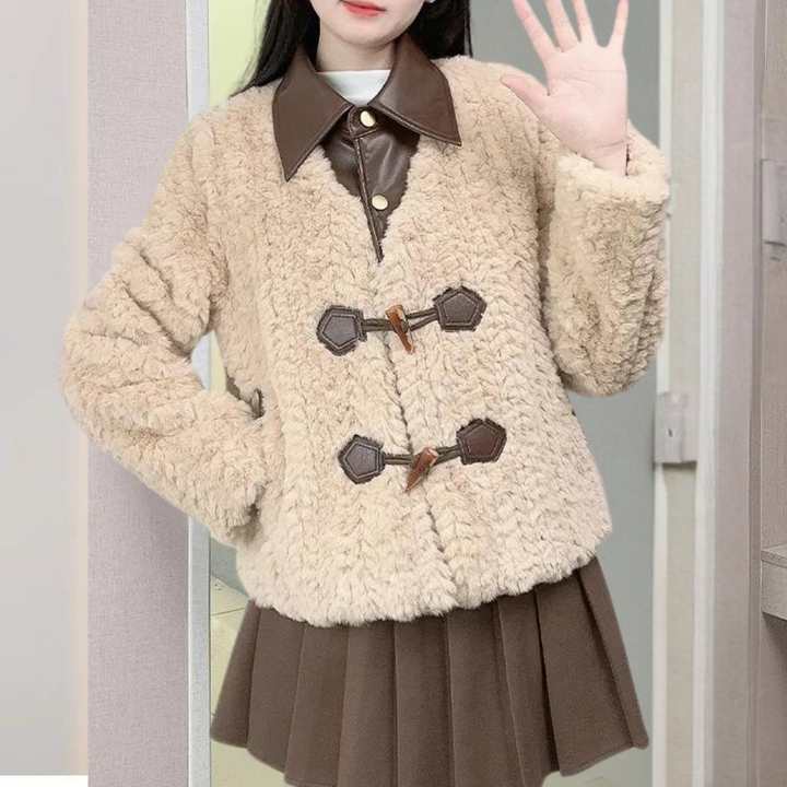Vrouw in beige teddyjas met bruine leren kraag en knopen, gecombineerd met bruine rok. Modieuze winterkleding, trendy damesmode.