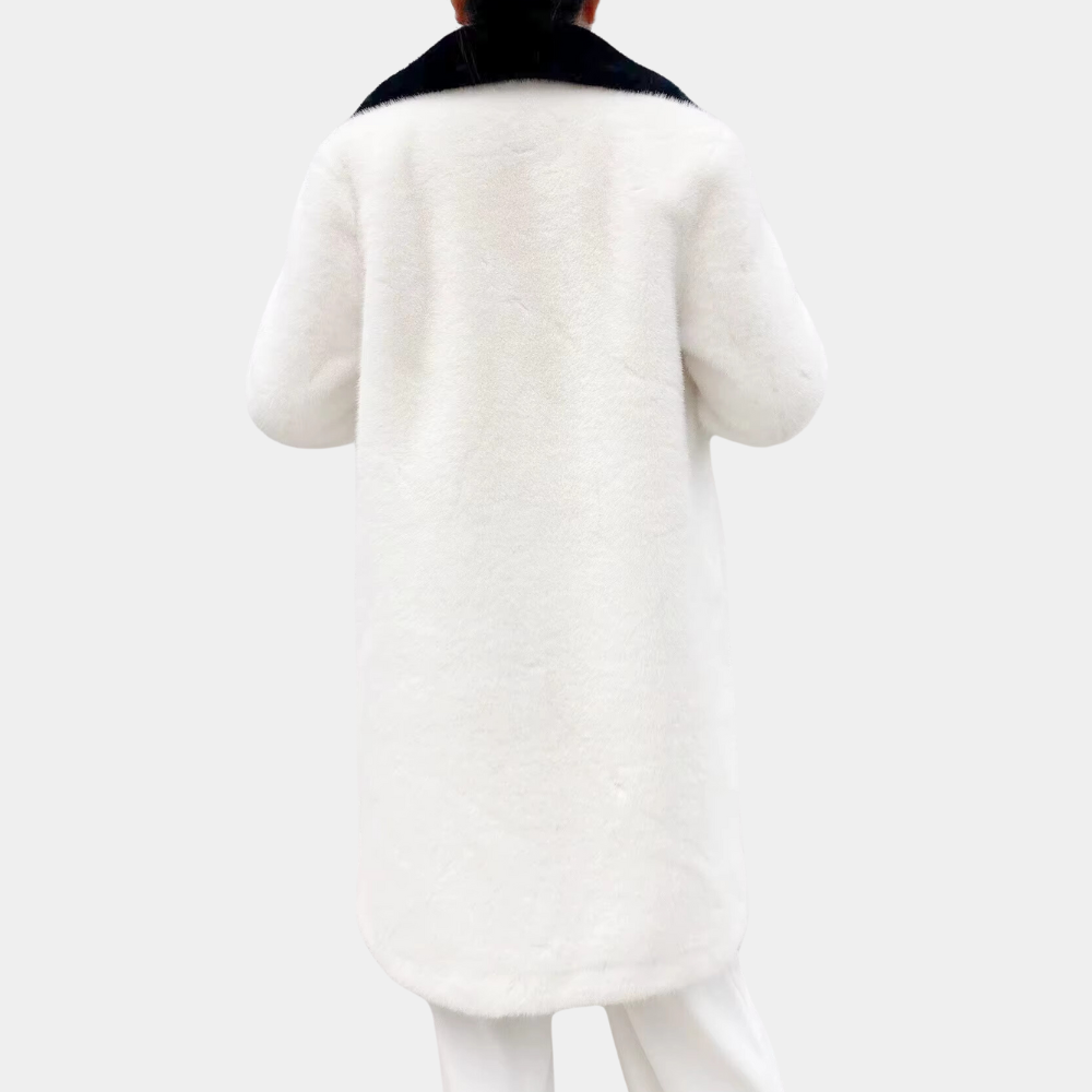 Witte damesjas van imitatiebont met zwarte kraag, rugaanzicht. Stijlvolle wintermode, warme en luxe uitstraling, perfect voor koude dagen.