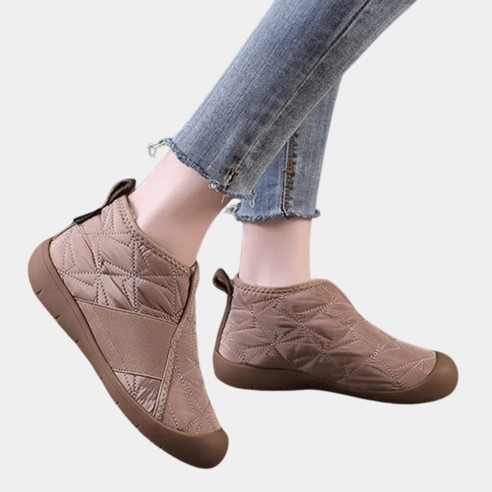 Beige gewatteerde enkellaarsjes met rubberen zool, gedragen met blauwe jeans. Comfortabele damesmode, casual schoenen voor dagelijks gebruik.