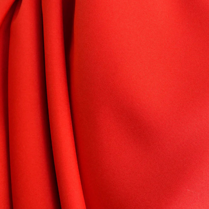 Rode stof close-up, gladde textuur, ideaal voor modeontwerp en interieurdecoratie. Hoogwaardige textielmaterialen, levendige kleur.