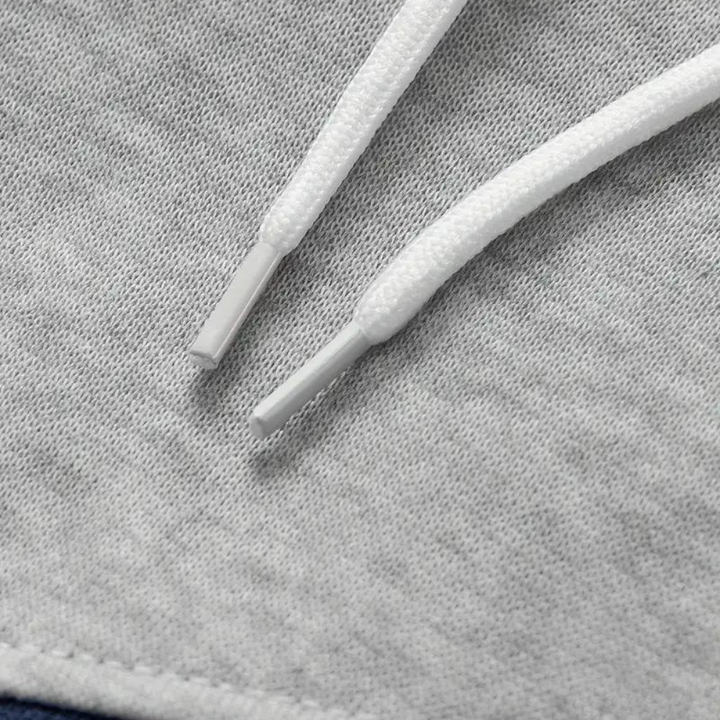 Grijze heren hoodie met capuchon, close-up van trekkoorden. Comfortabele en stijlvolle sweater, ideaal voor casual en sportieve outfits.