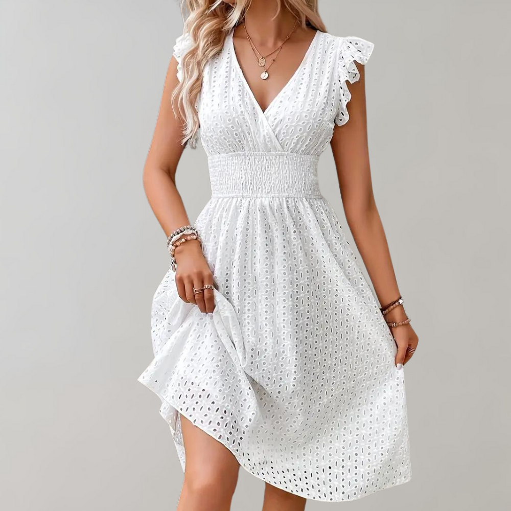 Vrouw in witte zomerjurk met kant, V-hals en ruches, perfect voor casual en elegante gelegenheden. Trendy damesmode, zomerkleding 2023.