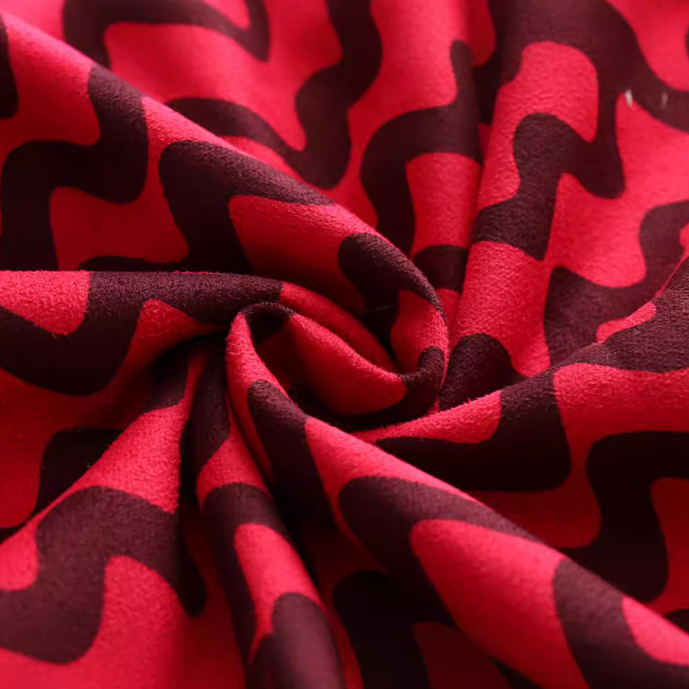 Rode en zwarte stof met golvend patroon, close-up. Ideaal voor modeontwerp, textielproductie en interieurdecoratie. Zachte textuur, levendige kleuren.