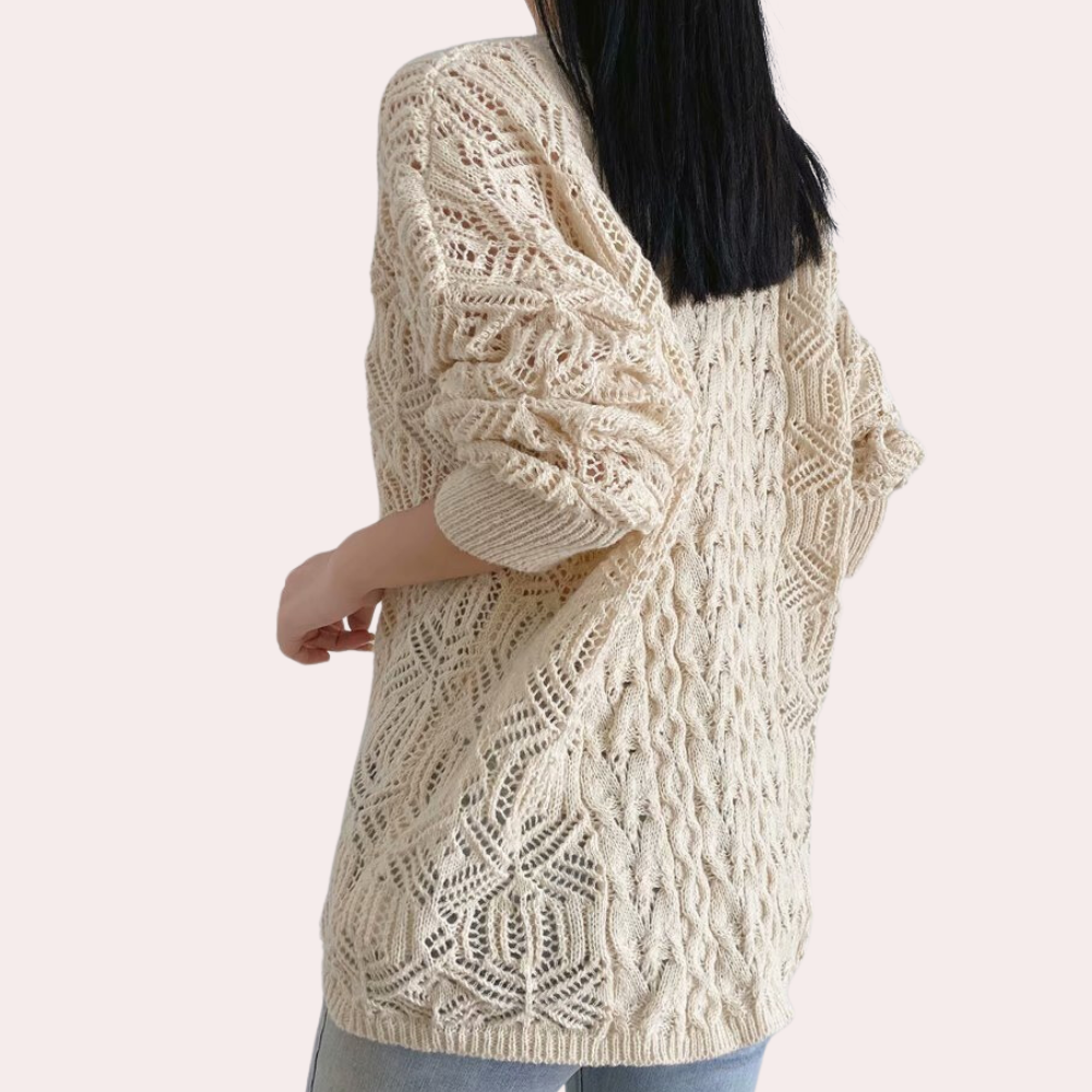 Beige gebreide trui met opengewerkt patroon, gedragen door vrouw. Modieuze dameskleding, herfst-winter stijl, comfortabele oversized pasvorm.
