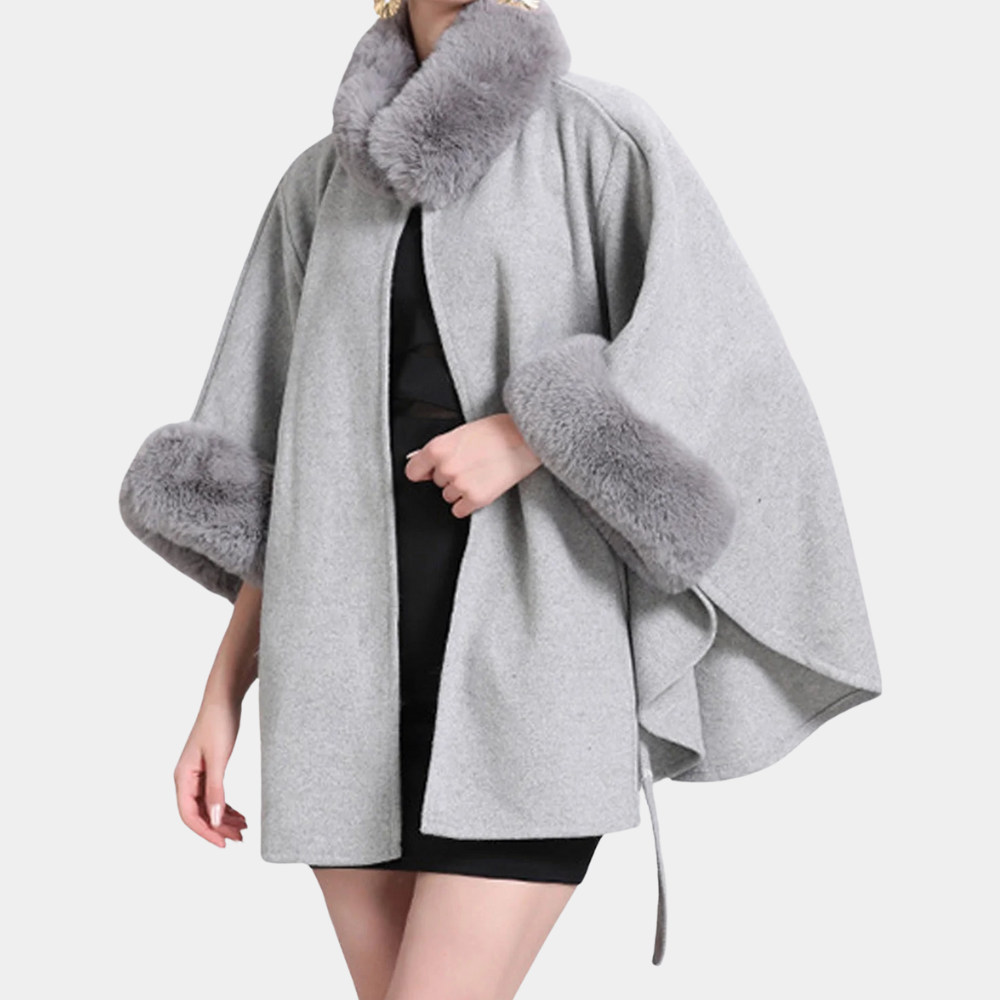 Grijze damescape met bontkraag en manchetten, elegante wintermode, stijlvolle jas voor dames, luxe kleding, modetrend herfst-winter.