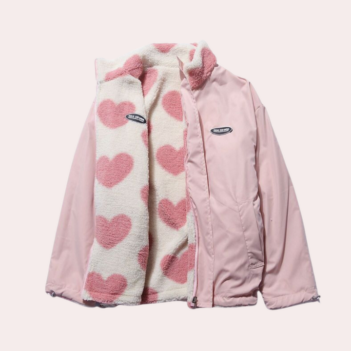 Roze jas met witte fleece voering en roze hartjes, modieus en warm, ideaal voor dames. Perfecte winterjas, trendy en comfortabel.