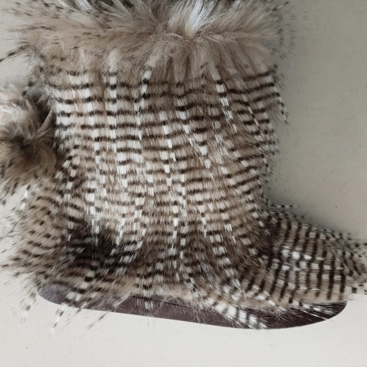 Pluizige, gestreepte winterlaars met bont, beige en bruine tinten, op witte achtergrond. Perfect voor koude seizoenen, modieuze dameslaars.