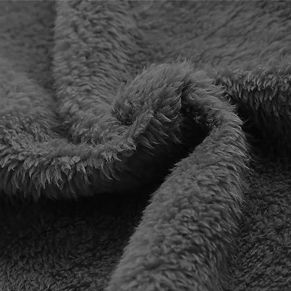 Grijze pluche fleece stof close-up, zachte textuur, ideaal voor warme dekens en kleding. Perfect voor wintermode en interieurdecoratie.