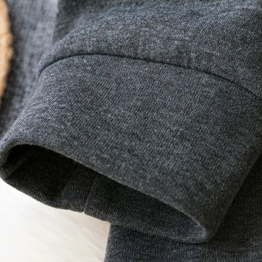 Donkergrijze katoenen trui mouw, close-up. Comfortabele, casual kleding, ideaal voor herfst- en wintermode. Zachte stof, hoogwaardige afwerking.