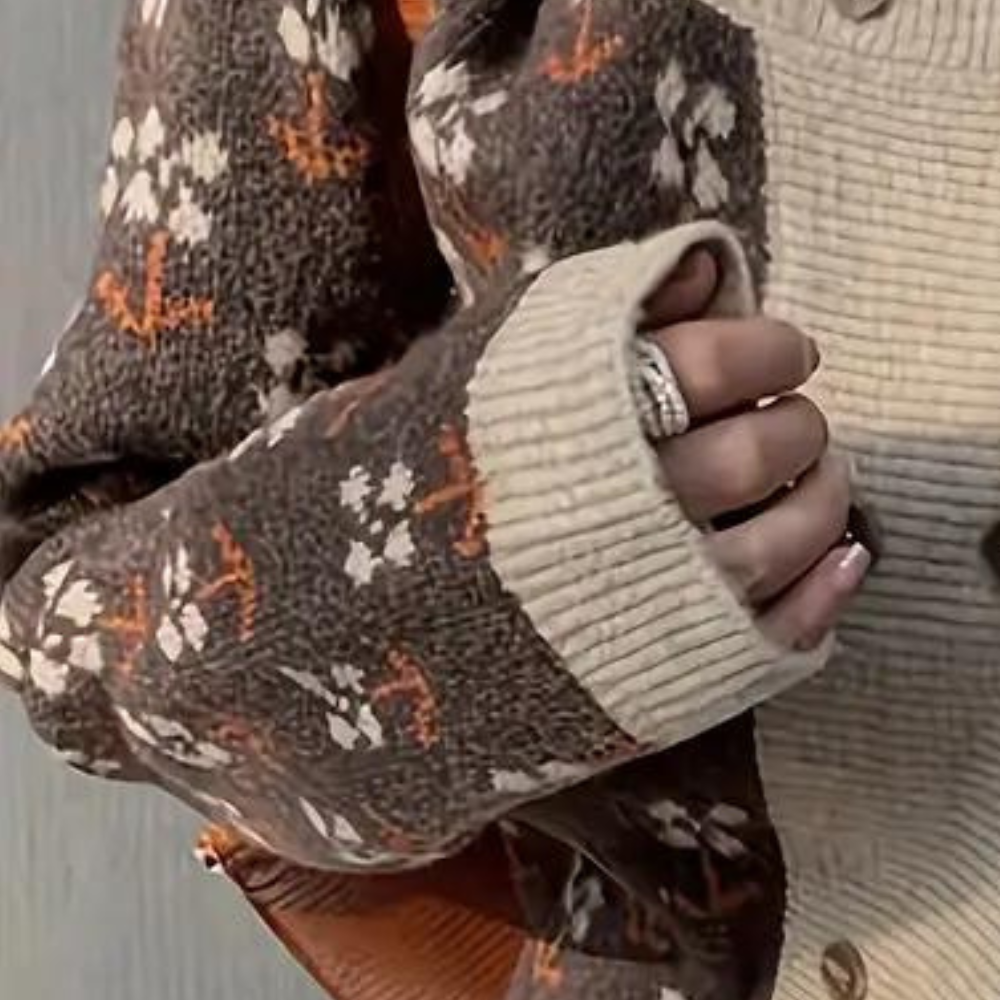 Bruine gebreide trui met bloemenpatroon en beige manchetten, gedragen door persoon met zilveren ring. Trendy herfstmode, comfortabele dameskleding.