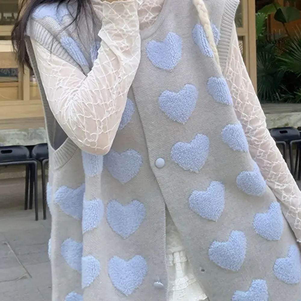 Grijze gebreide damesvest met blauwe hartjes, over kanten blouse. Trendy herfstmode, casual stijl, comfortabele kleding voor dagelijks gebruik.