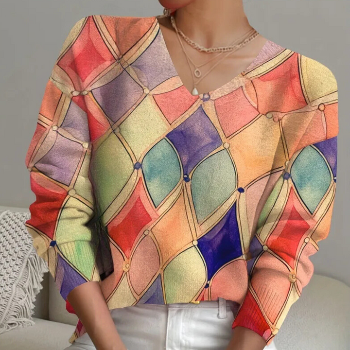 Vrouw draagt kleurrijke geometrische trui met ruitpatroon, pastelkleurige tinten. Modieuze dameskleding, trendy herfst- en winterstijl.