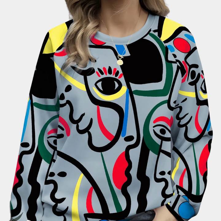 Grijze trui met abstracte gezichtenprint in felle kleuren, gedragen door vrouw. Moderne kunst, modetrend, kleurrijke kledingstijl.