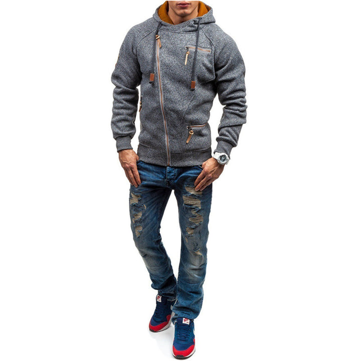 Man in grijze hoodie met rits en capuchon, versleten blauwe jeans en rode sneakers. Modieuze herenkleding, casual streetwear outfit.