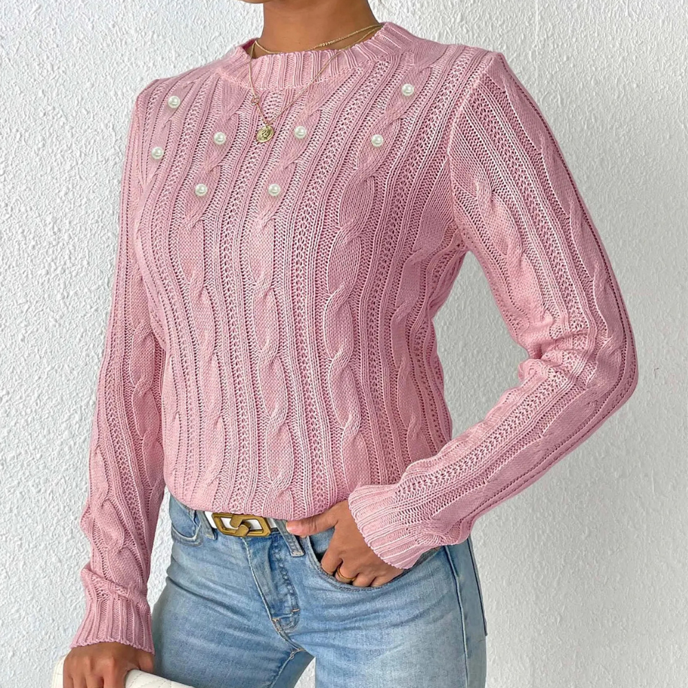 Roze kabeltrui met pareldetails, gedragen door model in blauwe jeans. Stijlvolle damesmode, herfstkleding, casual chic outfit.