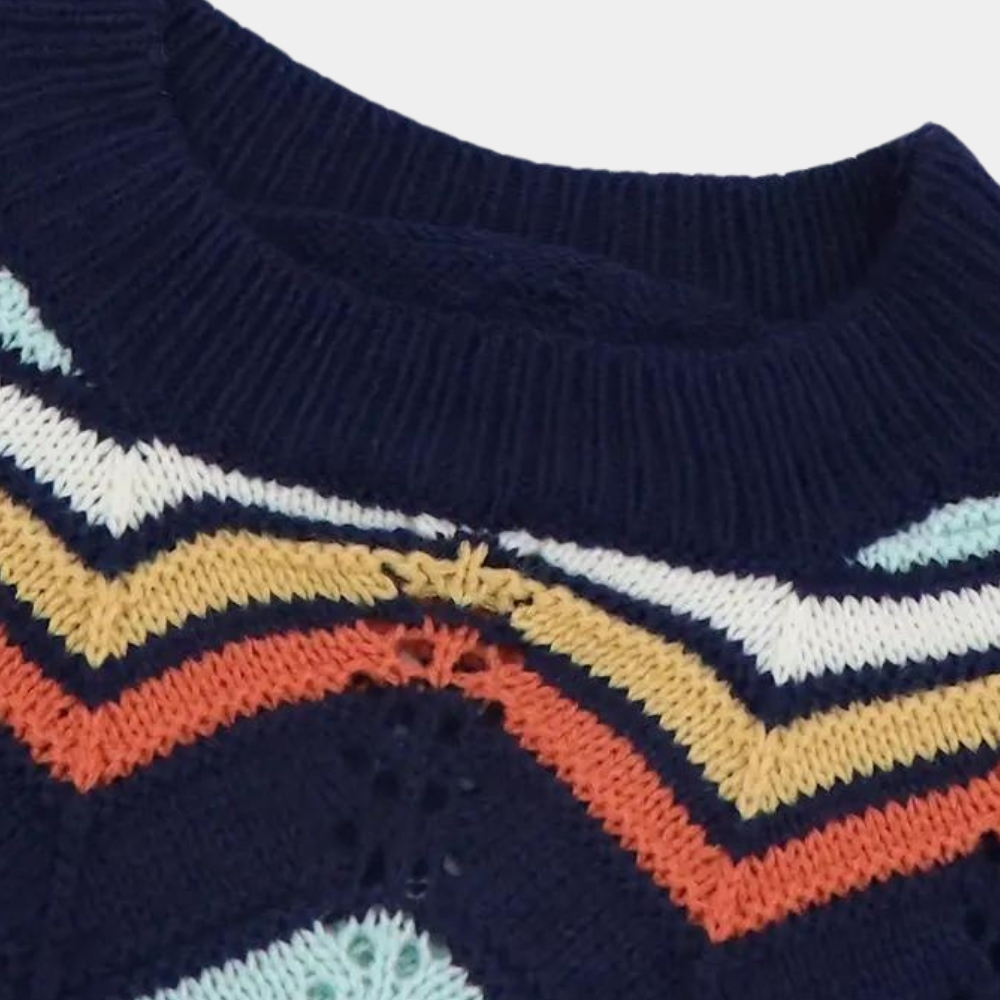 Donkerblauwe gebreide trui met kleurrijk zigzagpatroon, strepen in wit, geel, oranje en lichtblauw. Modieuze herentrui, winterkleding.