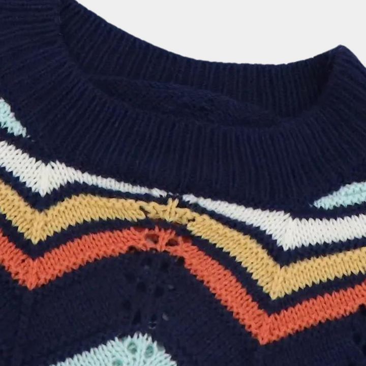 Donkerblauwe gebreide trui met kleurrijk zigzagpatroon, strepen in wit, geel, oranje en lichtblauw. Modieuze herentrui, winterkleding.