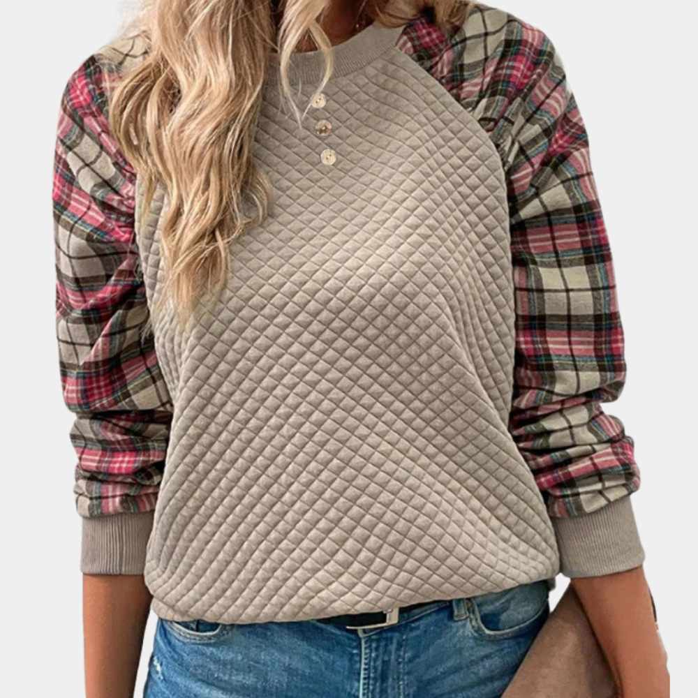 Vrouw draagt een beige gewatteerde trui met geruite mouwen, casual mode, herfstkleding, trendy damesoutfit, comfortabele stijl.