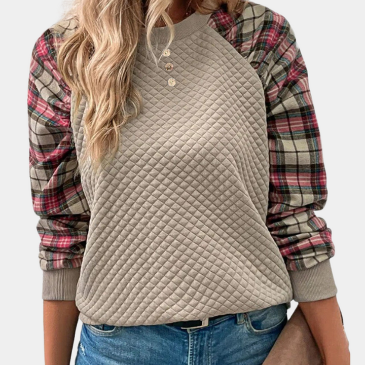 Vrouw draagt een beige gewatteerde trui met geruite mouwen, casual mode, herfstkleding, trendy damesoutfit, comfortabele stijl.