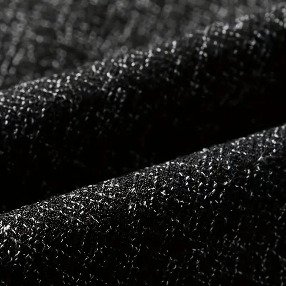 Zwarte glinsterende stof close-up, textuur van hoogwaardige blazerstof, elegant en stijlvol, geschikt voor formele kleding en modeontwerp.