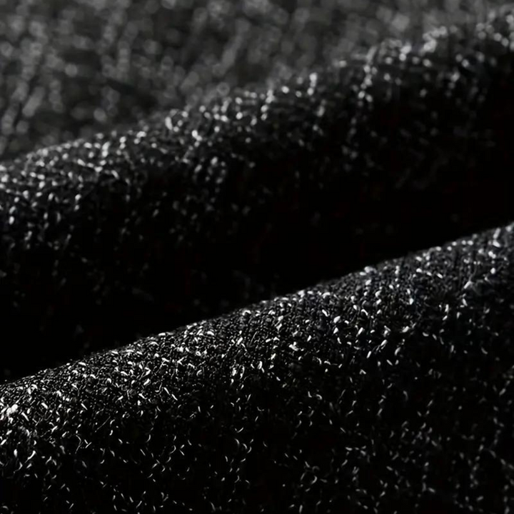 Zwarte glinsterende stof close-up, textuur van hoogwaardige blazerstof, elegant en stijlvol, geschikt voor formele kleding en modeontwerp.
