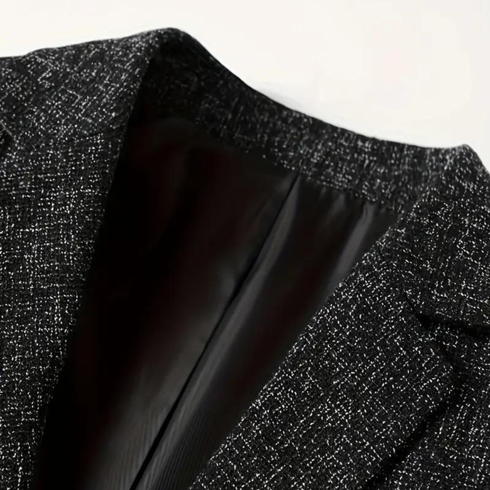 Zwarte wollen blazer met textuur, close-up van de kraag en voering. Stijlvolle herenmode, geschikt voor zakelijke en formele gelegenheden.