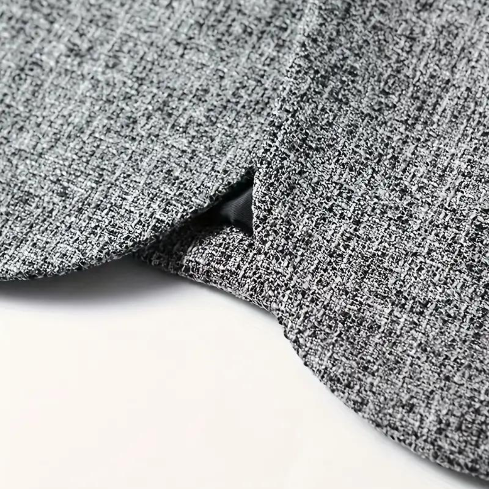 Grijze blazerstof met textuur, close-up van de zoom. Hoogwaardige mode, gedetailleerd weefsel, elegant ontwerp. Perfect voor stijlvolle kleding.