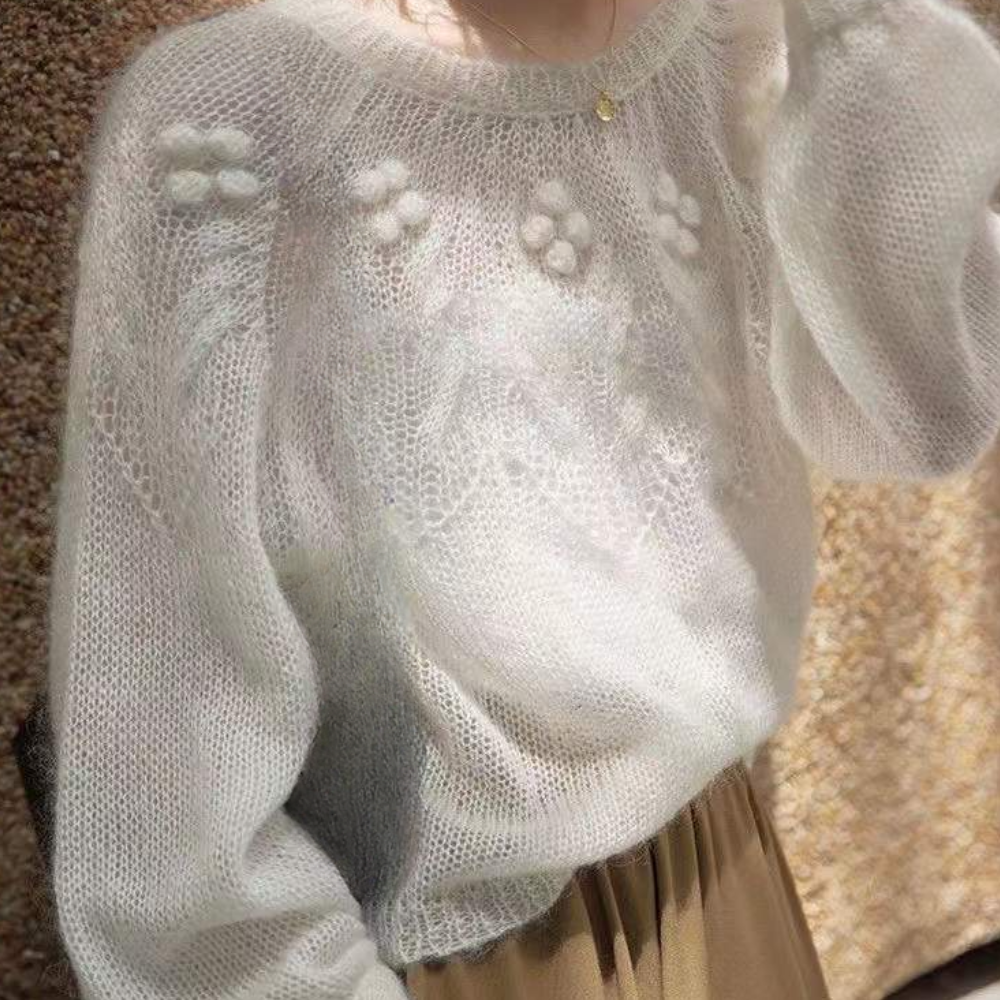 Witte gebreide trui met bloemenpatroon, zachte textuur, lange mouwen, modieuze dameskleding, herfst-winter stijl, casual elegantie.