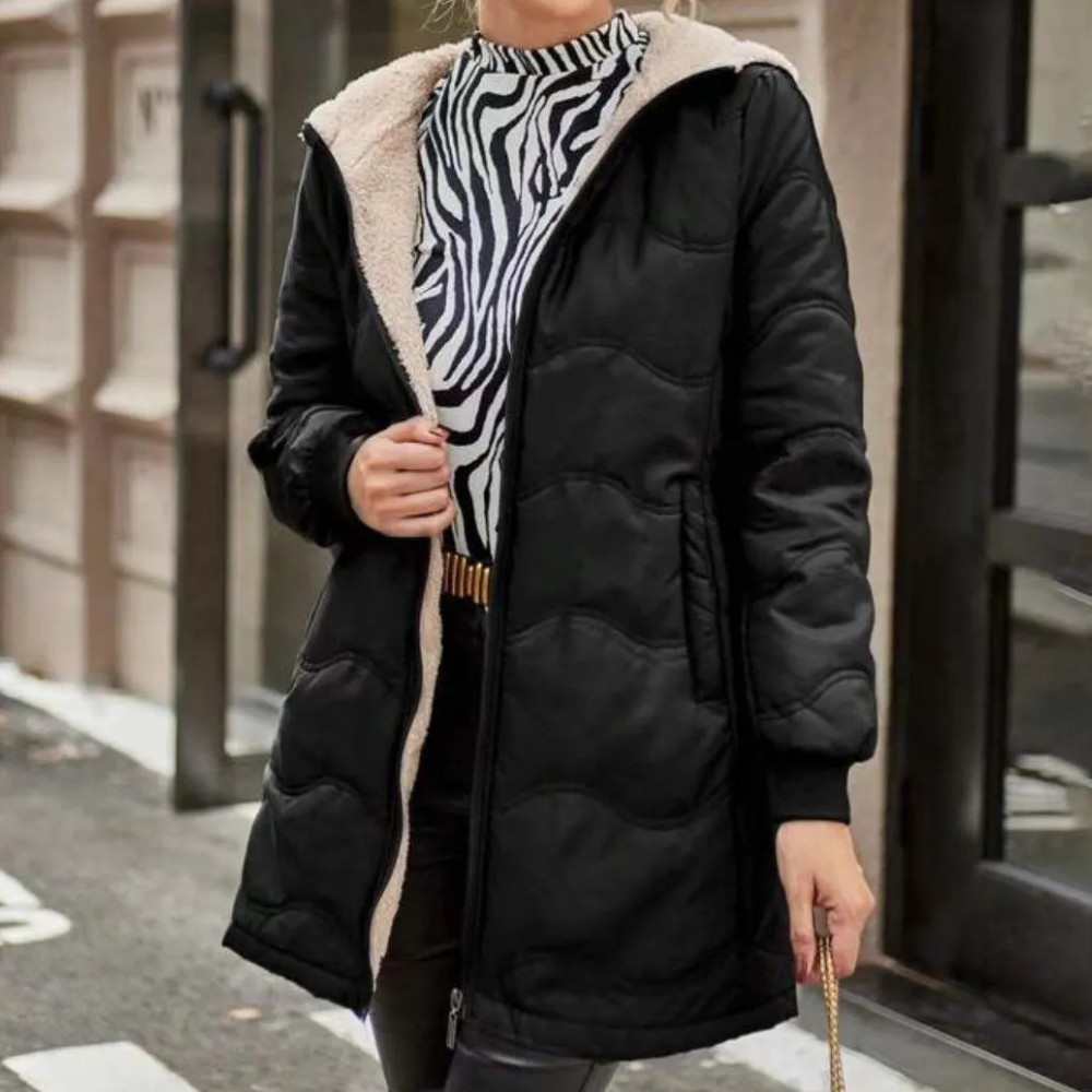 Vrouw in zwarte gewatteerde jas met capuchon en zebraprint trui, straatmode, herfst-winter kledingstijl, stedelijke achtergrond.