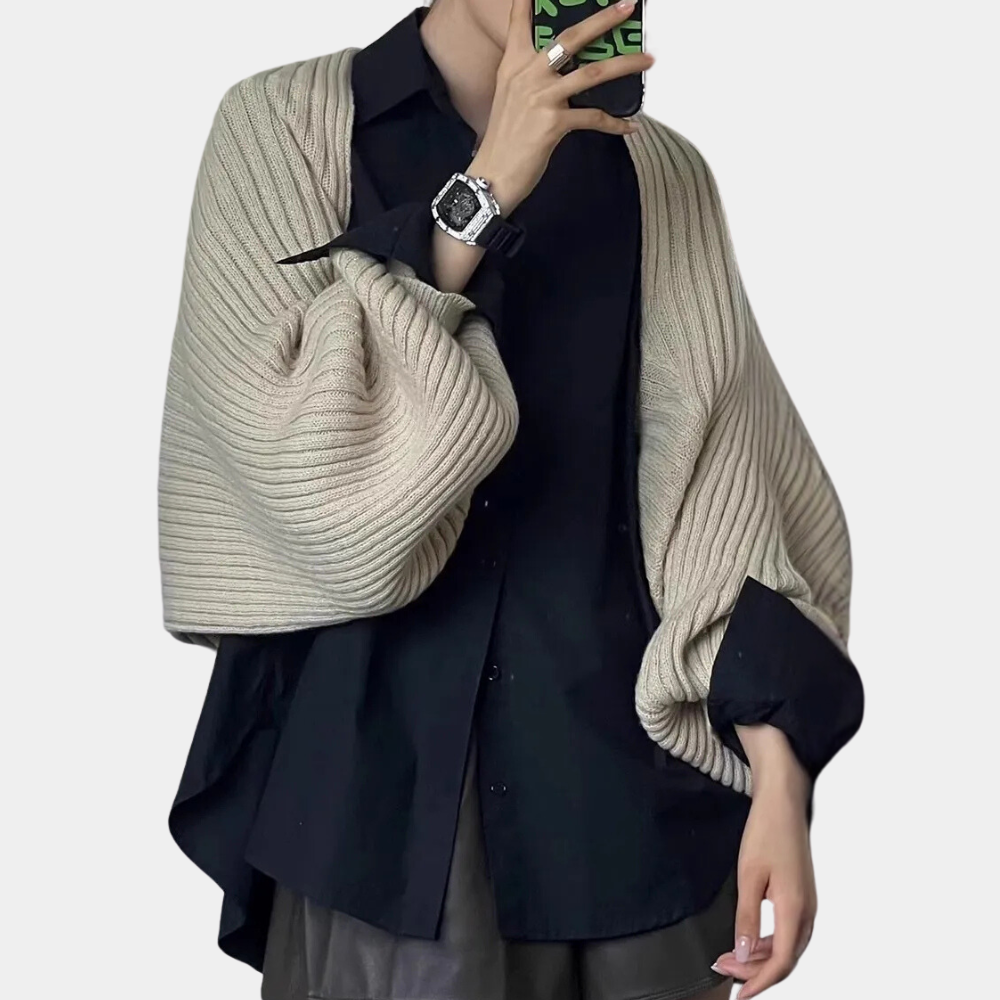 Beige gebreide sjaal over zwarte blouse, gedragen door persoon met groene telefoonhoes. Modieuze herfstkleding, casual stijl, trendy accessoires.