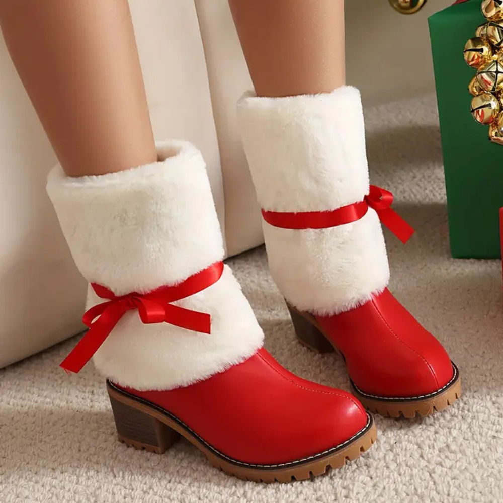 Rode laarzen met witte bontkraag en rode strik, kerstthema, op beige tapijt. Perfect voor wintermode en feestelijke outfits.