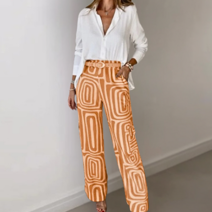 Vrouw in witte blouse en oranje geometrische printbroek, stijlvolle damesoutfit, modetrend, casual chique kleding, moderne damesmode.